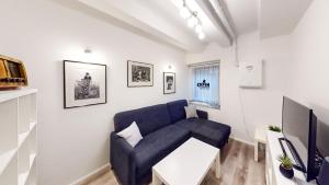 sala de estar con sofá azul y TV en Chaplin Apartment - Free Garage Parking, en Liubliana