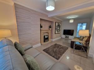 sala de estar con sofá y chimenea en Comfortable 3 Bed home Merthyr Tydfil near Bike Park Wales & Brecon Beacons, en Dowlais