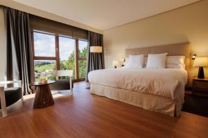 - une chambre avec un grand lit et une grande fenêtre dans l'établissement Hotel & Spa El Mirador de Ulzama, à Urrizola-Galáin