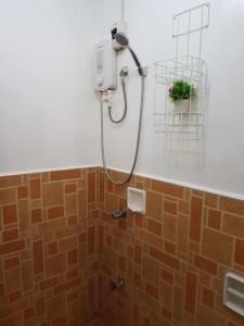 łazienka z prysznicem wyłożona brązowymi kafelkami w obiekcie 2-storey house san pedro laguna belinda condotel 3 w mieście San Pedro