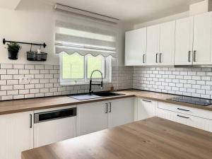 a kitchen with white cabinets and a sink at L'Ulmeusienne contemporaine in Le Meux