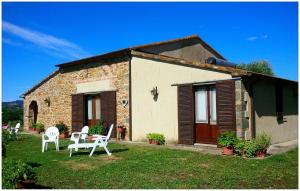 a small stone house with white chairs in the yard at Agriturismo San Giusto in Montiano