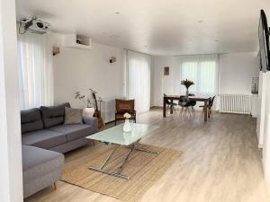 a living room with a couch and a table at L'Ulmeusienne contemporaine in Le Meux