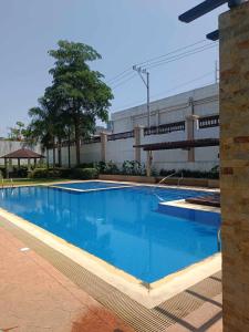 a large blue swimming pool in front of a building at Iza's Alabang Studio Apartment in Manila