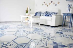 sala de estar con sofá blanco y suelo azul y blanco en Mela & Cannella accommodation, en Minori