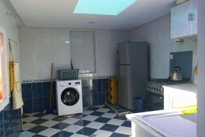 a kitchen with a washing machine in a room at Villa luxueuse au centre du golf in Bouznika