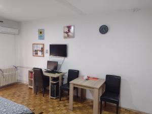 Apartman Vesna في بانيا كوفيلياتشا: غرفة بها مكتب وبه جهاز كمبيوتر وكراسي