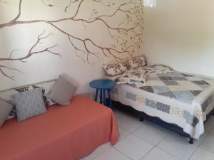 ein Schlafzimmer mit einem Bett, einem Tisch und einer Wand in der Unterkunft Condomínio encantador com piscina em Itaúna in Saquarema + 33 Fotos