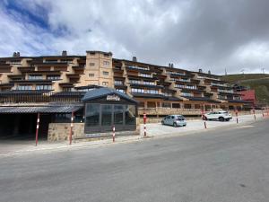 ein großes Gebäude mit Autos auf einem Parkplatz in der Unterkunft APARTMENT SAN BERNARDO Zona Alta with free garage parking and free WIFI in Sierra Nevada