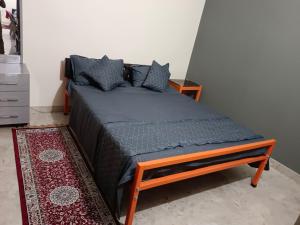 Bett in einem Zimmer mit einer blauen Decke und Kissen in der Unterkunft Eastern guest house in Patna