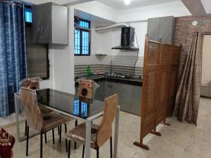 a kitchen with a table and chairs in a room at Eastern guest house in Patna