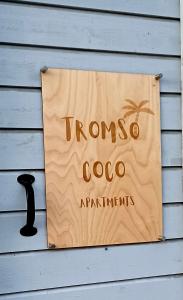 a sign on the side of a house with a palm tree at Tromso Coco Apartments in Center in Tromsø