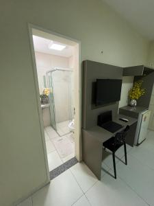 a room with a desk and a bathroom with a shower at SD Plaza Hotel in Sobral