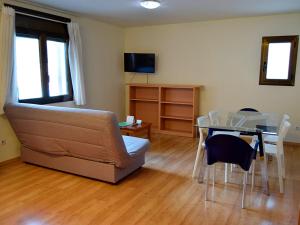 ein Wohnzimmer mit einem Sofa und einem Tisch in der Unterkunft Apartamentos Pantebre 3000 in Pas de la Casa