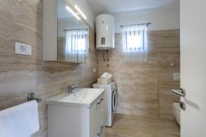a bathroom with a sink and a toilet and a mirror at Newly renovated apartments in Funtana in Funtana +63 photos