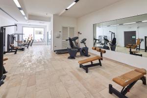 un gimnasio con cintas de correr elípticas y un espejo grande en Riva Marina Resort - CDSHotels, en Carovigno