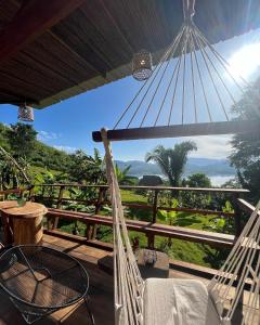 a hammock on a balcony with a view of the jungle at Tierra Alta, Refugio de Montaña, Sauce in Sauce