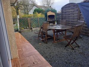 a patio with a table and chairs and a grill at charmant loft à la campagne,Hauts de France ,Somme in Rubempré