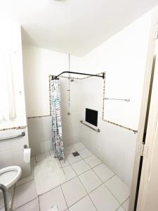 a bathroom with a shower and a toilet at Hotel Concord in Campo Grande