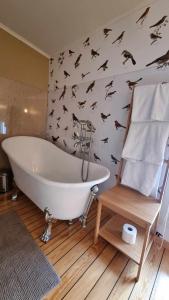 een badkamer met een wit bad en vleermuizen aan de muur bij Herrgård in Jörn
