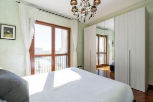 1 dormitorio con cama blanca y ventana grande en Perugino's Peaceful Sky Terrace, en Ponte Galeria