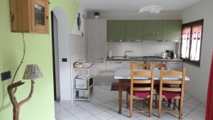 a kitchen with green cabinets and a table and chairs at La Petite Maison in Aosta