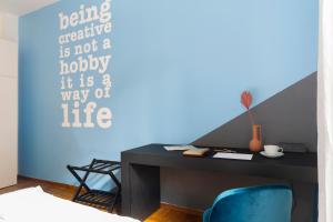 een slaapkamer met een bureau en een blauwe muur bij Everyday Apartments Corte Petroni in Bologna