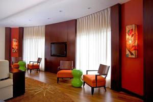 a waiting room with chairs and a tv in a building at Courtyard by Marriott Port of Spain in Port-of-Spain