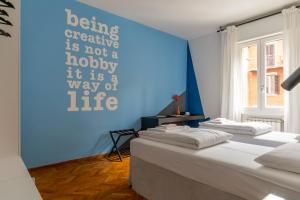 - 2 lits dans une chambre avec un mur bleu dans l'établissement Everyday Apartments Corte Petroni, à Bologne