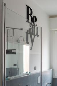 a mirror above a sink in a bathroom at Everyday Apartments Corte Petroni in Bologna