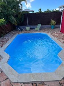a large blue swimming pool in a backyard at Le Neem in Saint-François