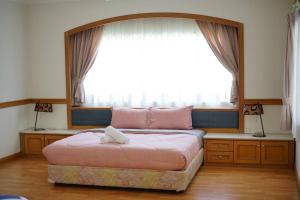 1 cama en un dormitorio con ventana grande en White House BEACH Executive Residence en Tanjung Bungah