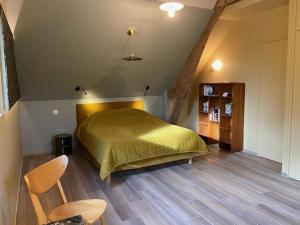 - une chambre avec un lit et une couverture verte dans l'établissement Les Herbes Flottantes, à Englesqueville-en-Auge