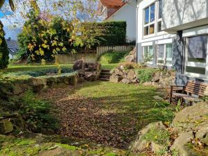a yard with a bench in front of a house at Ferienwohnung Waldblick in Heiligenzell +19 photos