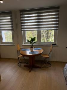 un tavolo con sedie in una stanza con finestre di Murano Apartaments Promenada studio a Varsavia