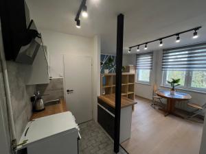 una cucina con lavandino e tavolo in una stanza di Murano Apartaments Promenada studio a Varsavia