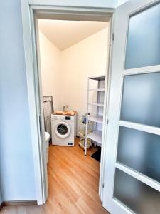 a door to a laundry room with a washer and dryer at L'Appartamentino Montagna in Biella
