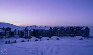 een groep gebouwen in de sneeuw bij schemering bij Luxury Apartments With Mountain View in Neo New Gudauri in Goedaoeri +16 foto's
