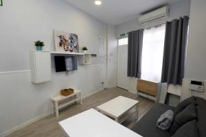 ein Wohnzimmer mit einem Sofa und einem TV in der Unterkunft La casita de Valvanera in Madrid