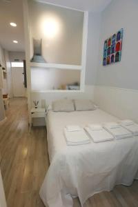 1 dormitorio con 1 cama blanca en una habitación en La casita de Valvanera, en Madrid