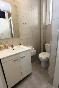 ein Badezimmer mit einem weißen Waschbecken und einem WC in der Unterkunft La casita de Valvanera in Madrid