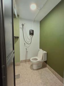 een badkamer met een toilet in een groene muur bij Penang Heritage Home in George Town