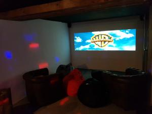 モンジェネヴルにあるSlope-Side Chalet w/Jacuzzi, Home Cinema, for 16 Guestsのソファ2台と大画面テレビが備わる客室です。