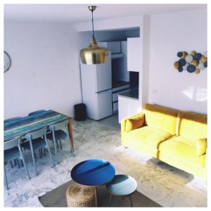 a living room with a yellow couch and a table at COTE PLAGE HYPER CENTRE - Bord de mer in Le Grau-du-Roi