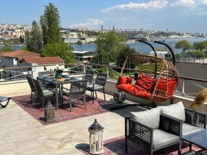 un patio avec une balançoire, une table et des chaises dans l'établissement Waterfront Villa by the Tram - Private Terrace with Dome & Golden Horn View in Fatih, à Istanbul