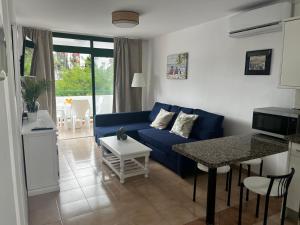 a living room with a blue couch and a table at Playa Ingles central cozy apartment in Maspalomas