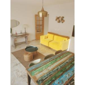 a living room with a yellow couch and a table at COTE PLAGE HYPER CENTRE - Bord de mer in Le Grau-du-Roi
