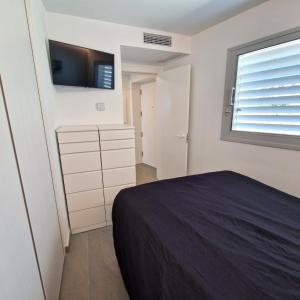 een slaapkamer met een bed en een tv aan de muur bij Dúplex con vistas impresionantes in Fuengirola