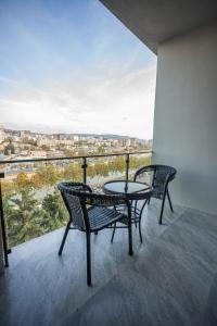 2 stoelen en een tafel op een balkon met uitzicht bij Luxury Apartments in the center in Tbilisi City