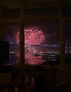 una ventana con vistas a una pantalla de fuegos artificiales en Best Bosphorus View Entire 2 Bedroom Flat, en Estambul